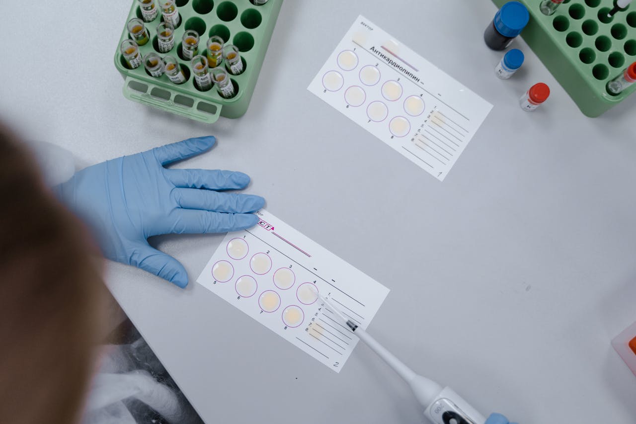 Top view of a scientist analyzing samples using lab equipment indoors.